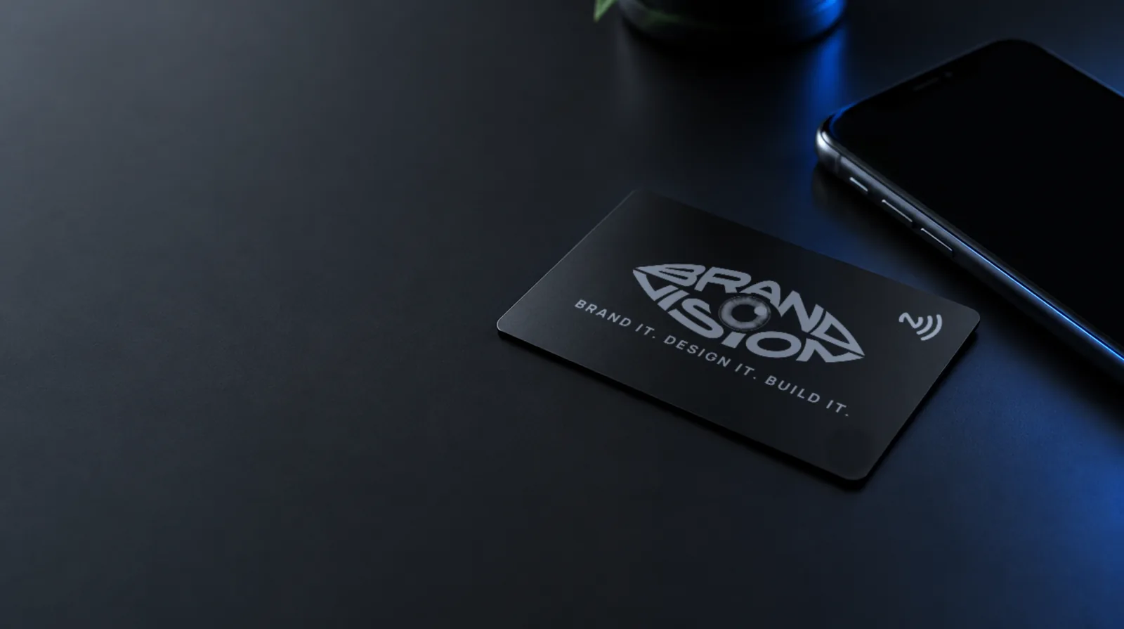 Kovová NFC vizitka z čierneho anodizovaného hliníka vedľa smartfónu